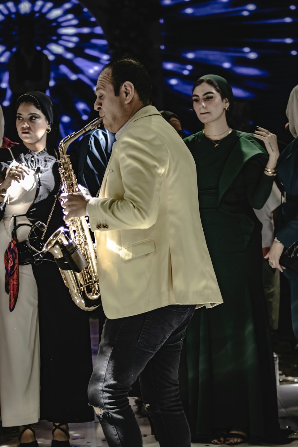 Un musicista suona un sassofono dorato durante un evento al chiuso.